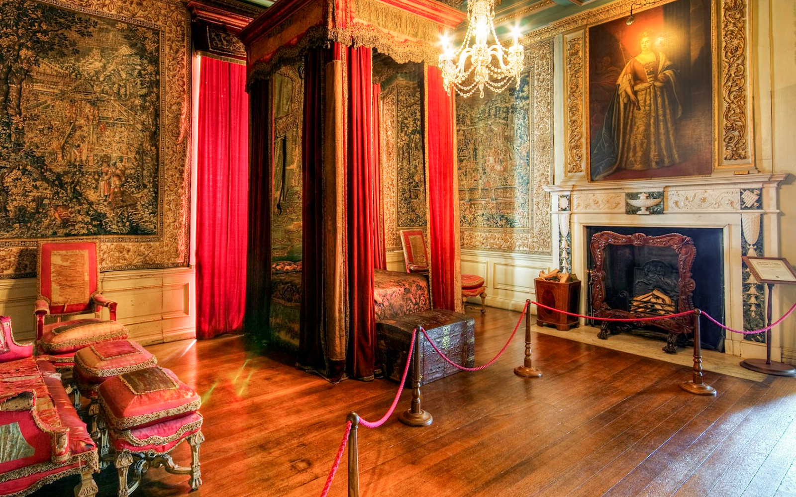 Warwick Castle bedroom with ornate canopy bed, tapestries, and fireplace.