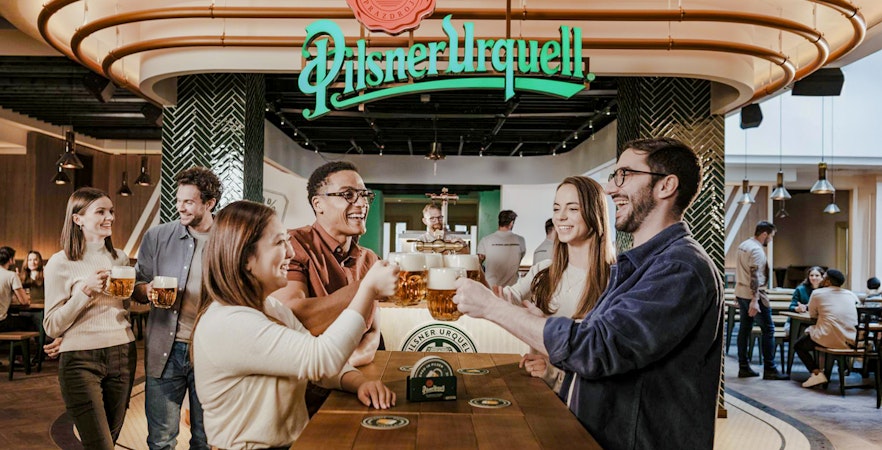 Tourists enjoying beer tasting at Pilsner Urquell The Original Beer Experience in Prague.