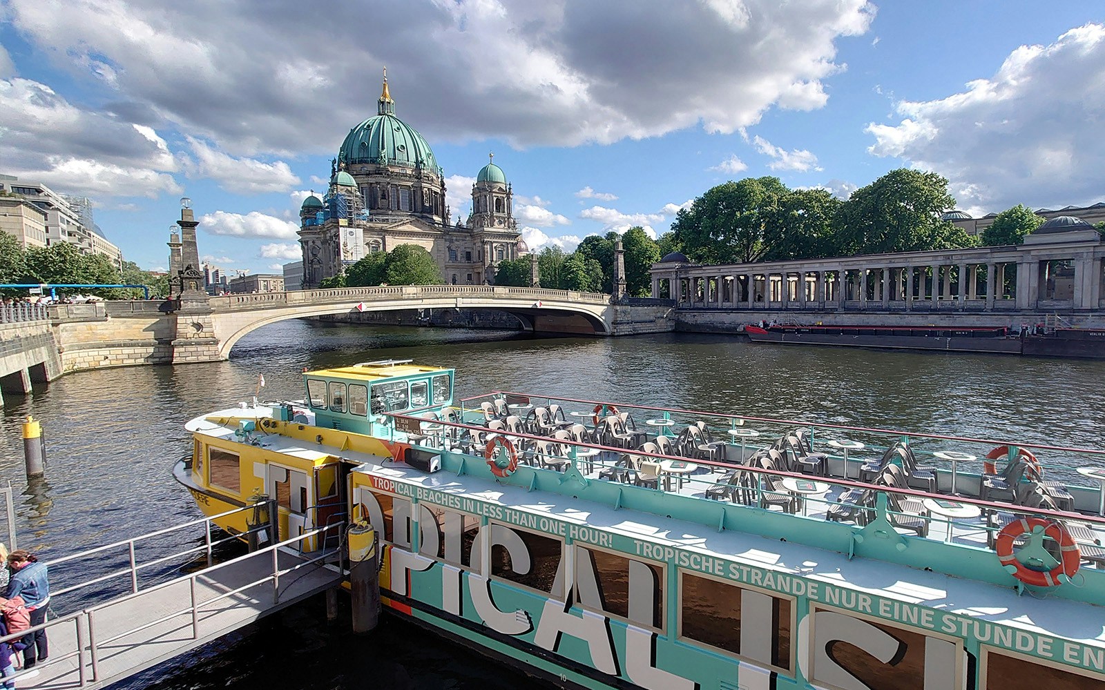 Sightseeing cruise boat on the River Spree with Berlin Cathedral in the background.