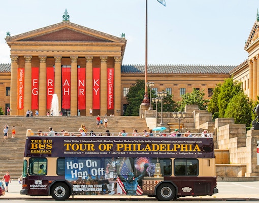 Philadelphia double-decker bus tour passing historic landmarks and cityscape.