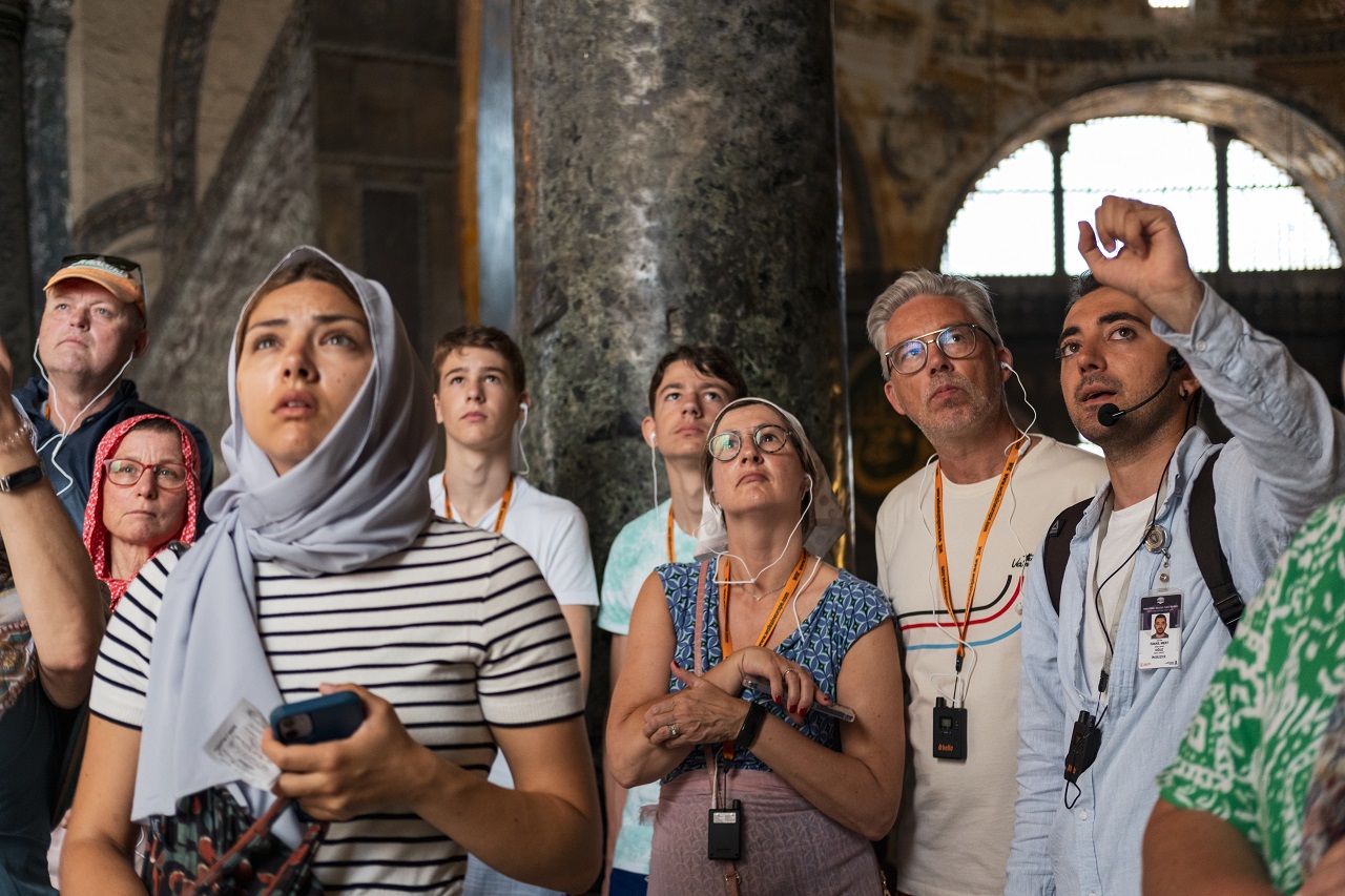 Guided tour group inside Hagia Sophia, Istanbul, listening to a guide's explanation.