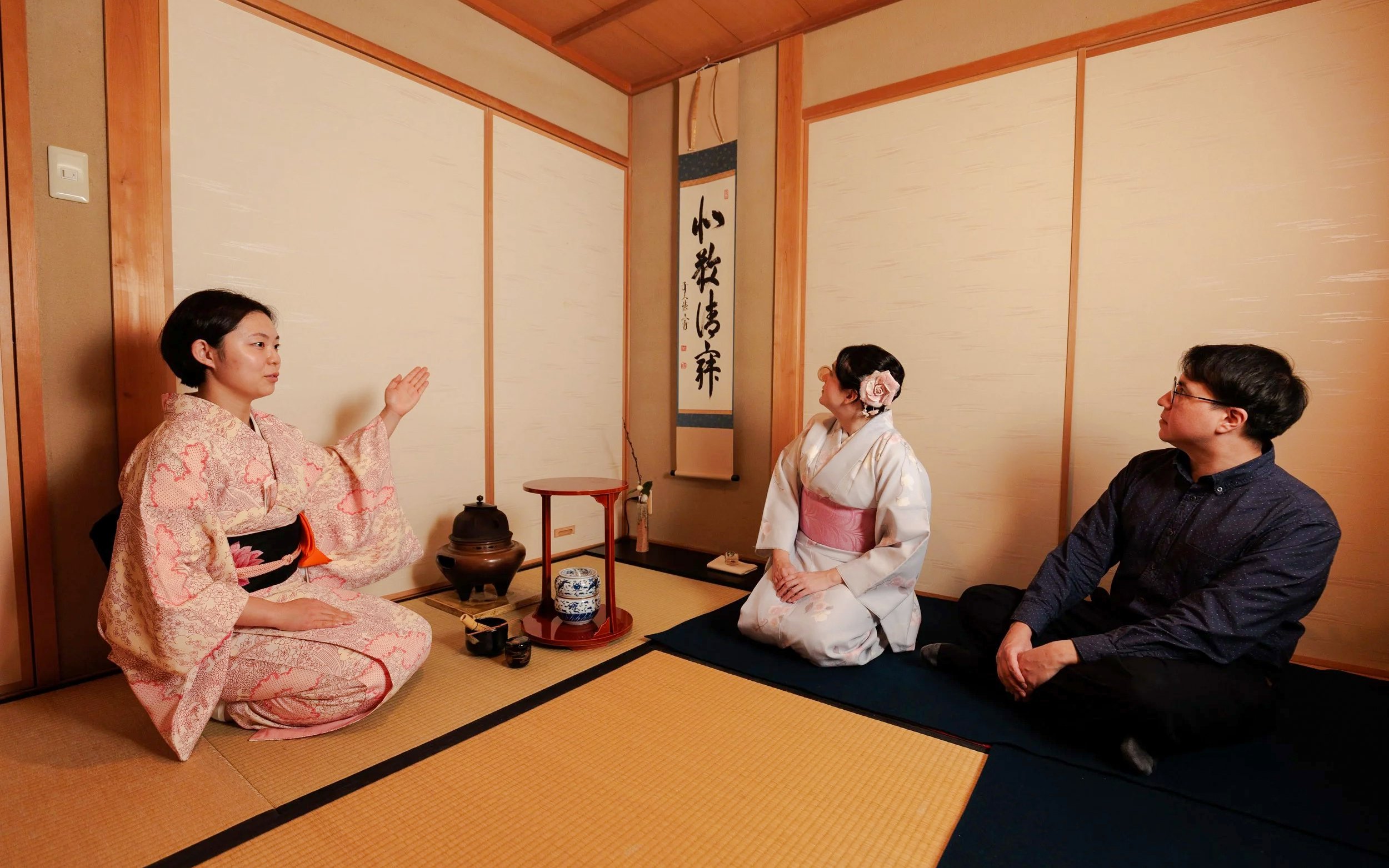 Participants in traditional attire during a Japanese tea ceremony.