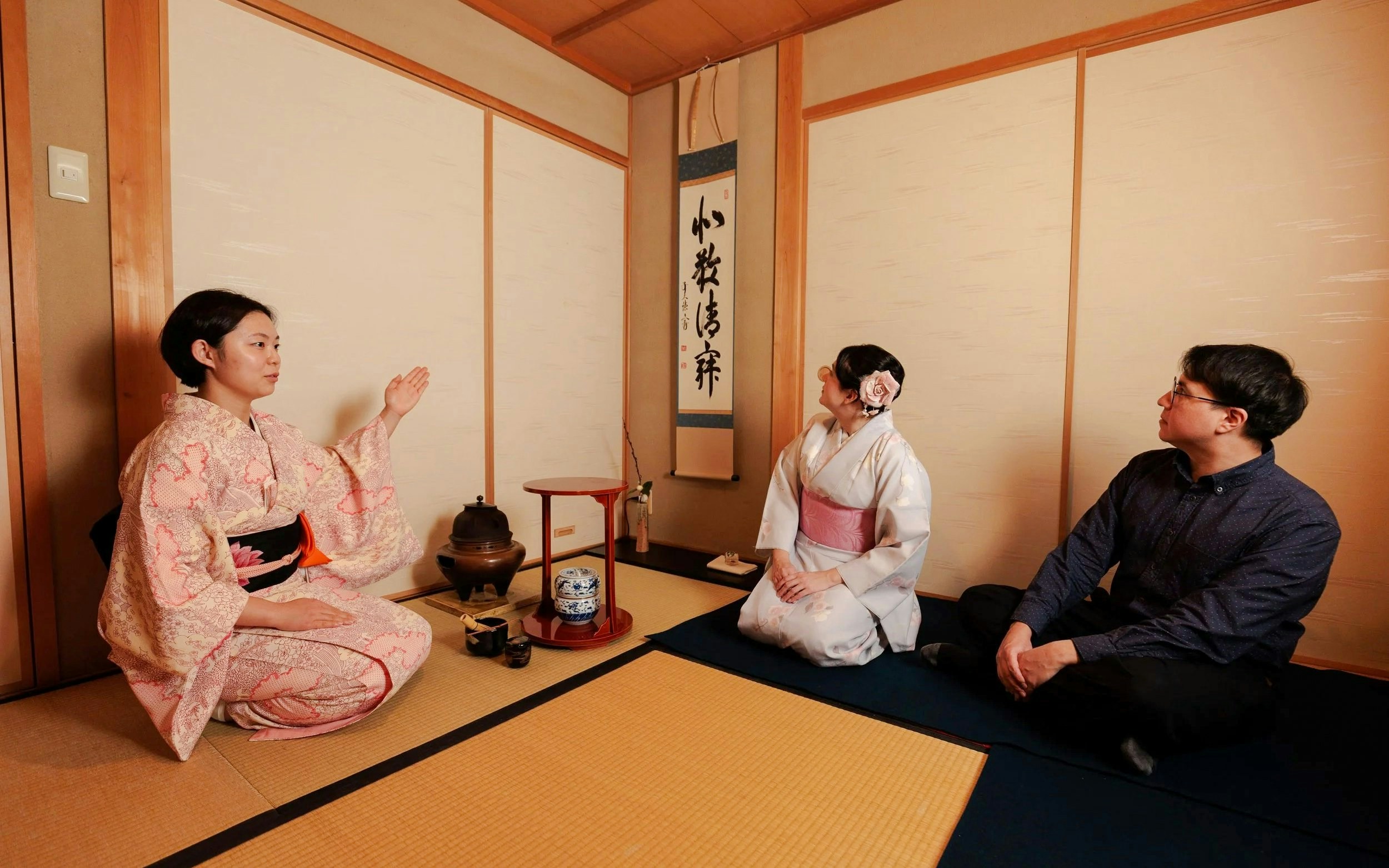 Participants in traditional attire during a Japanese tea ceremony.