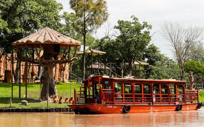 Boat tour passing animal enclosures at Shanghai Wild Animal Park.
