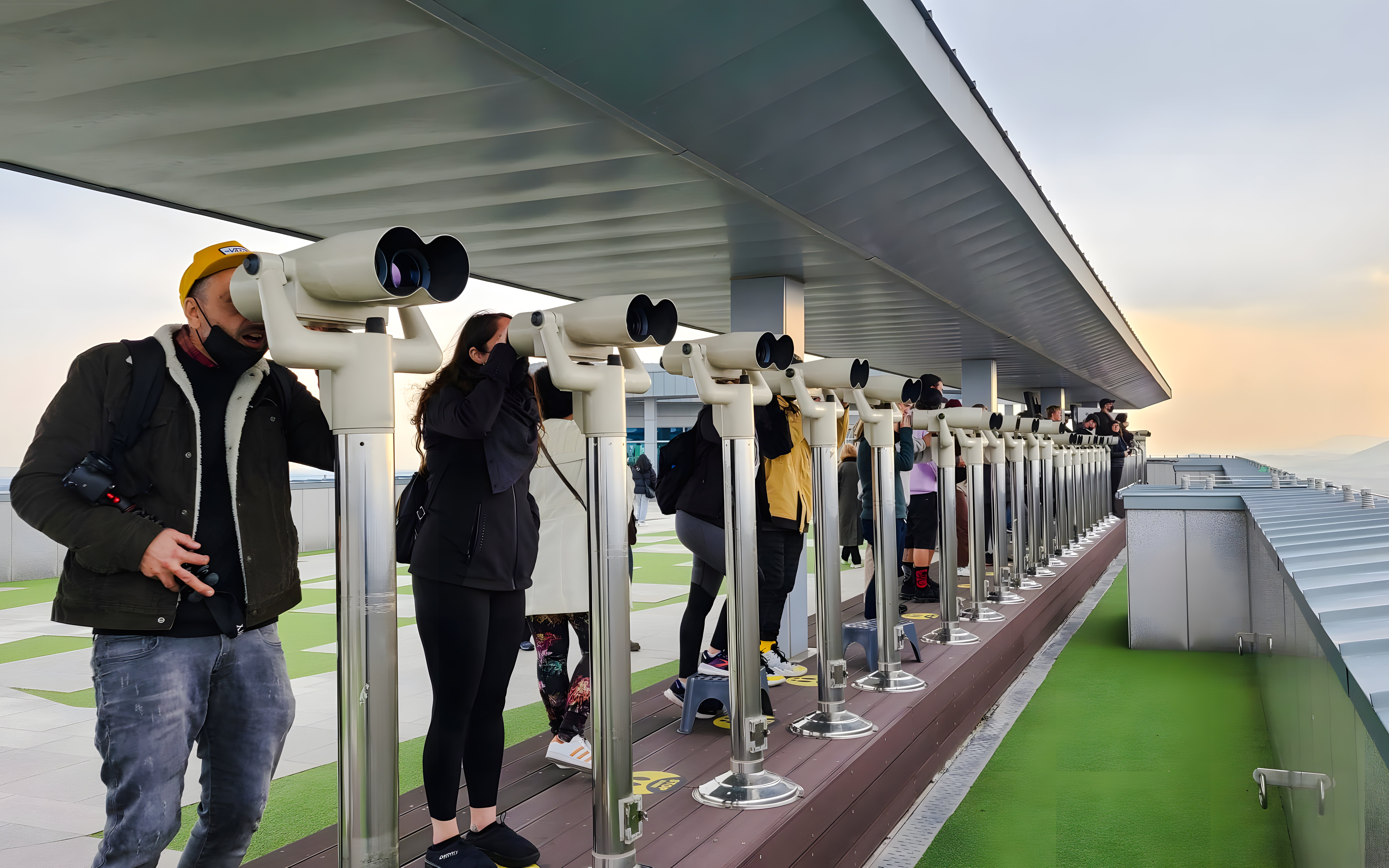 Visitors using binoculars at a DMZ observation deck in South Korea.