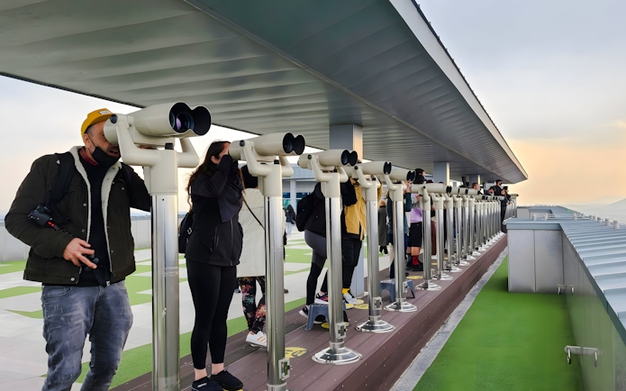 Visitors using binoculars at a DMZ observation deck in South Korea.