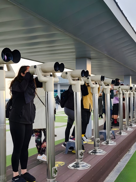 Visitors using binoculars at a DMZ observation deck in South Korea.
