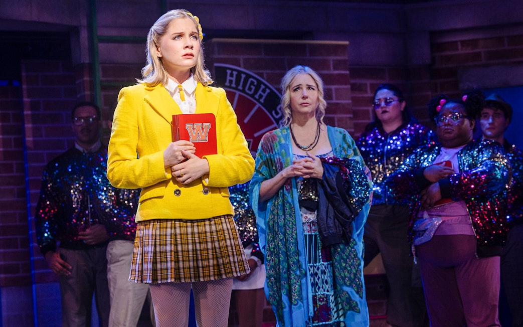 Cast performing a scene from Heathers: The Musical on stage.