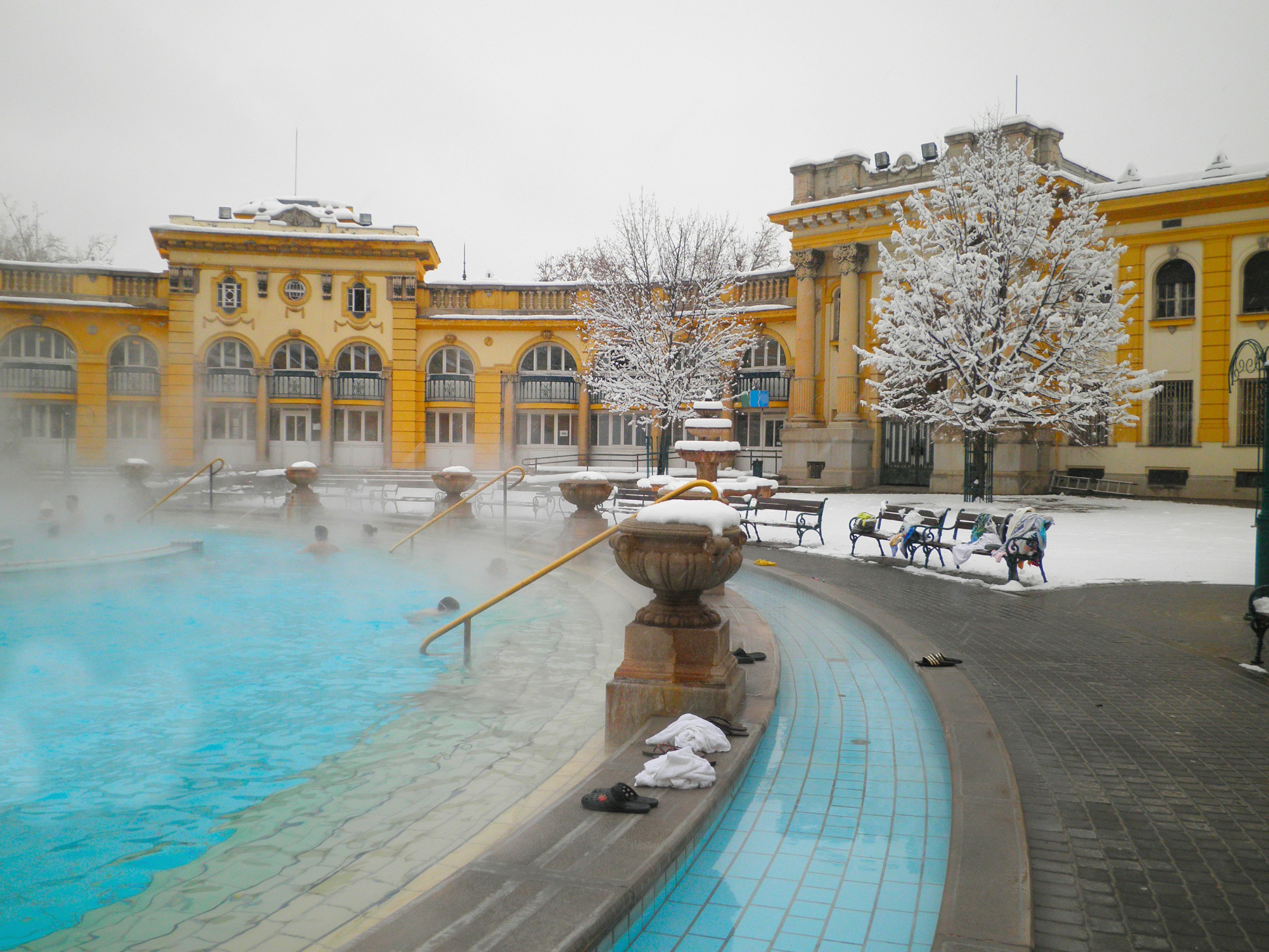 Széchenyi thermal baths in Budapest with steam rising from outdoor pools in February.