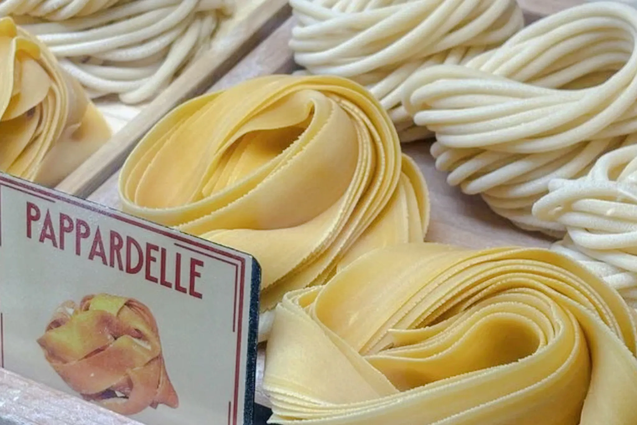 Pappardelle pasta displayed in a Florence cooking class with Tuscan wine.