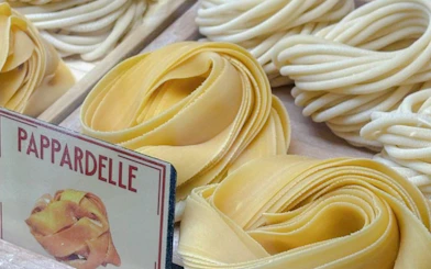 Pappardelle pasta displayed in a Florence cooking class with Tuscan wine.