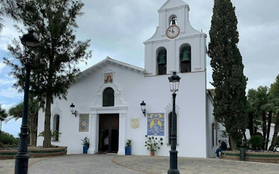 White church with bell tower in Benalmádena Pueblo, part of self-guided city exploration game.
