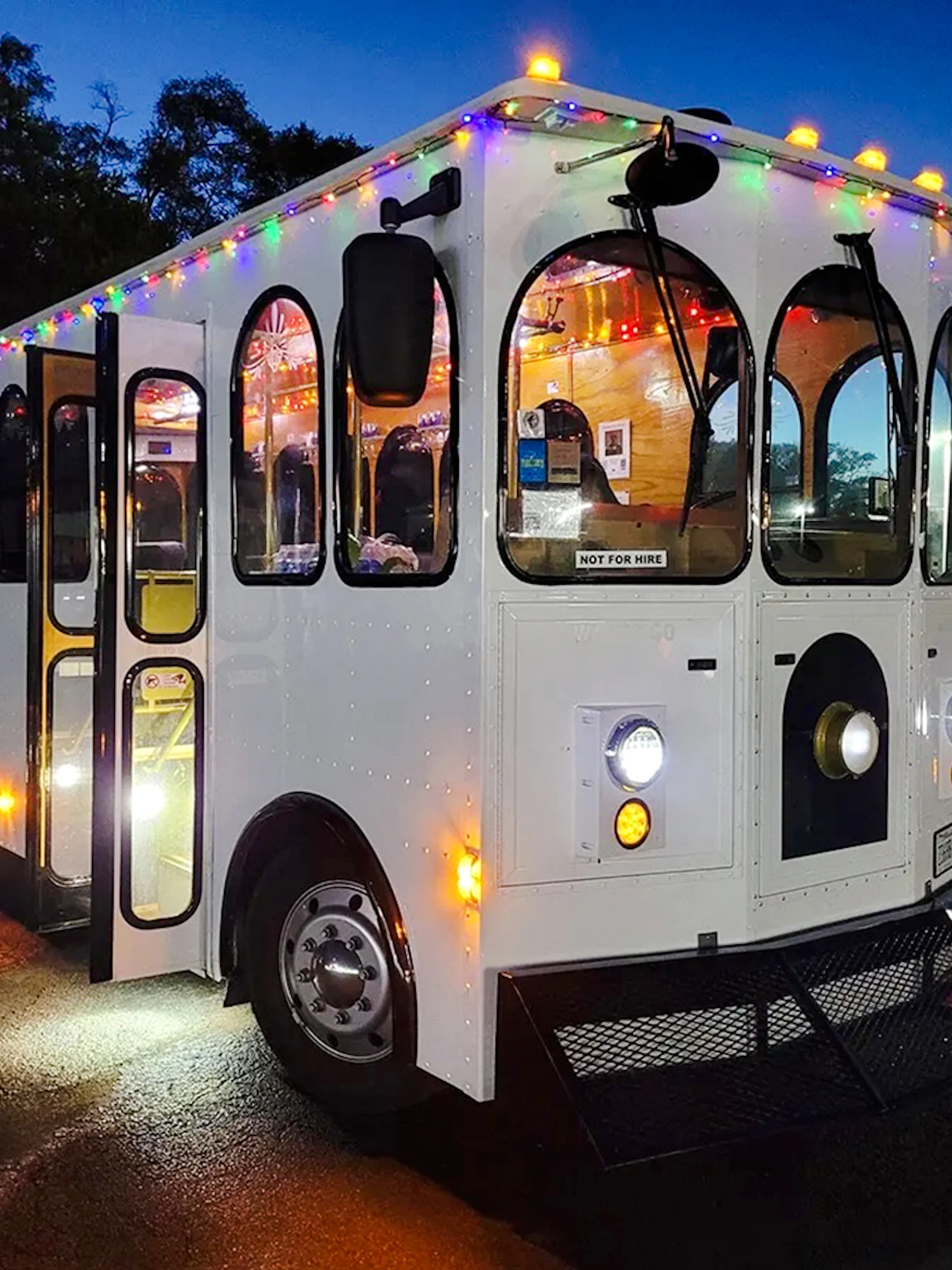 Trolley decorated with holiday lights for Philadelphia tour at dusk.