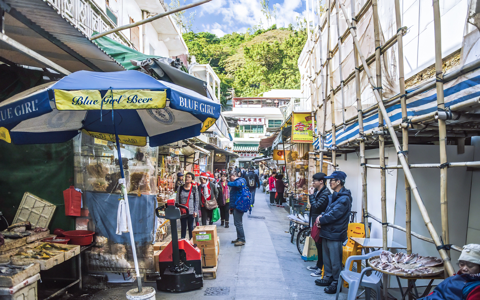 Street market scene on Lantau Island, Hong Kong, with people shopping and local stalls.