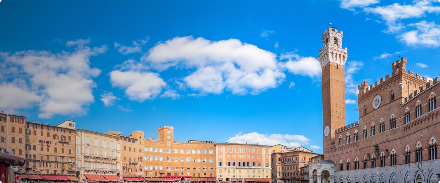 Piazza del Campo with Torre del Mangia in Siena, Italy under a clear blue sky.