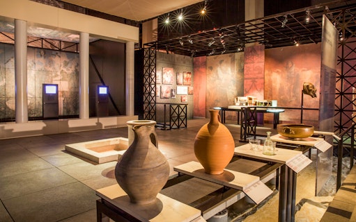 Museum exhibit with ancient pottery and artifacts at Pont du Gard, France.