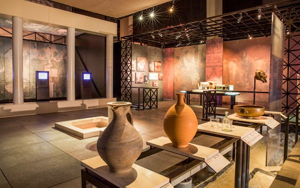 Museum exhibit with ancient pottery and artifacts at Pont du Gard, France.