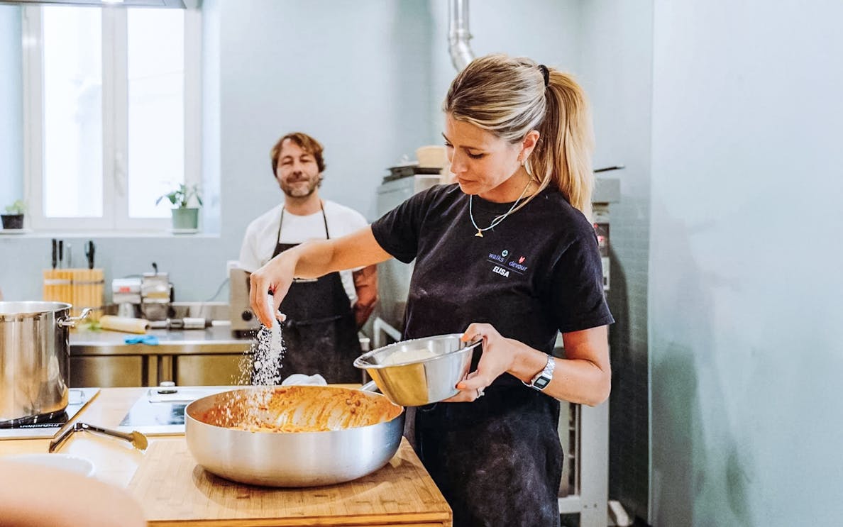 Tourists making pasta with a local chef in a Rome cooking class.