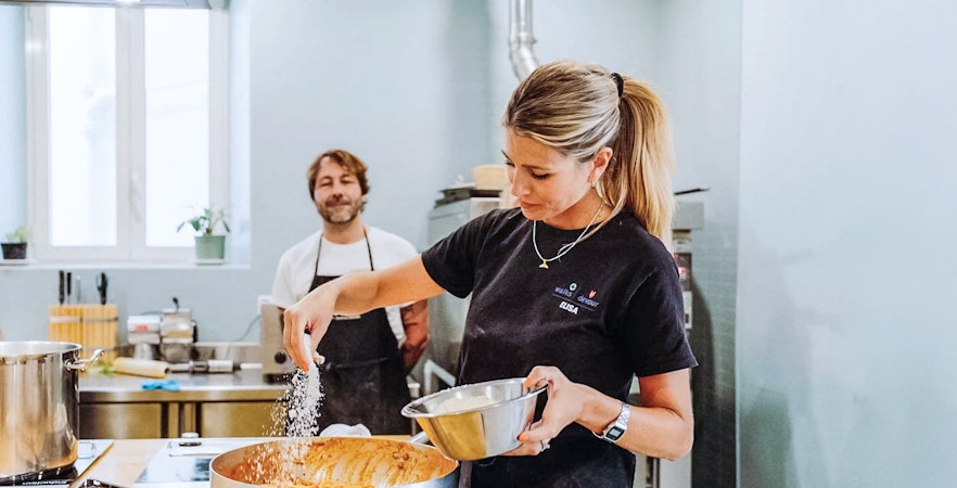 Pizza with mozzarella and greens on a table during a pizza-making course.