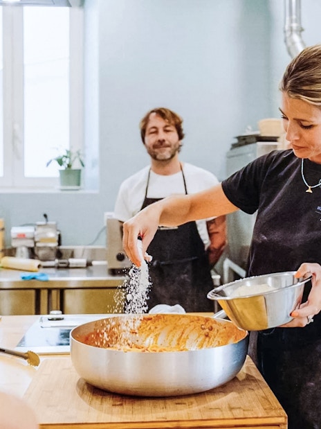 Tourists learning pasta making with a local chef in a kitchen setting.