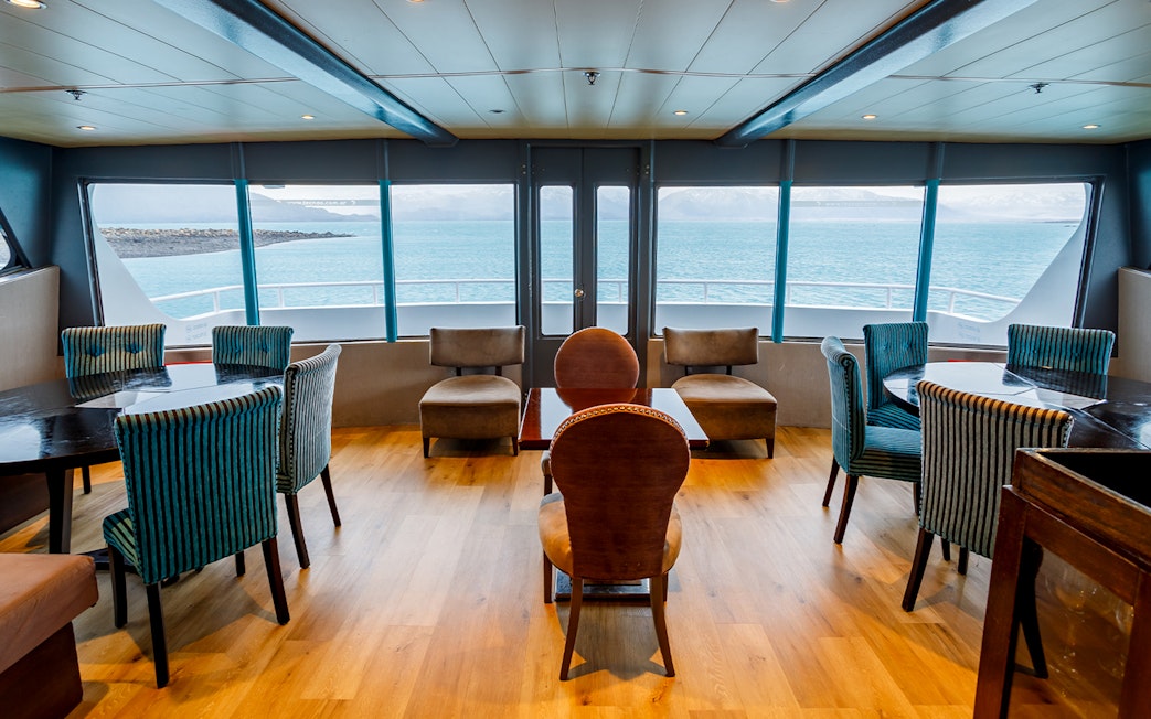 Premium boat interior with seating and large windows overlooking the water during Perito Moreno, Spegazzini & Upsala tour.