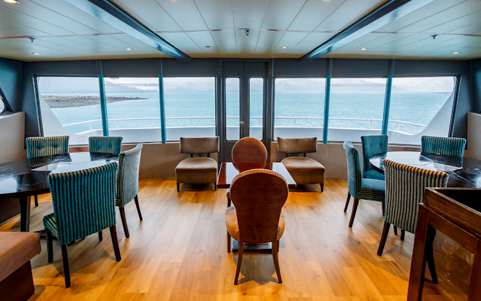 Premium boat interior with seating and large windows overlooking the water during Perito Moreno, Spegazzini & Upsala tour.