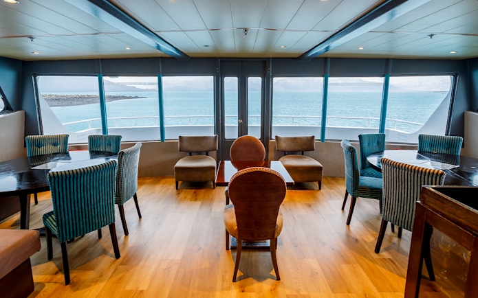 Premium boat interior with seating and large windows overlooking the water during Perito Moreno, Spegazzini & Upsala tour.