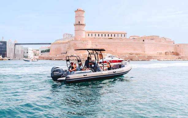 Boat tour in Marseille harbor with view of Notre-Dame de la Garde basilica in the background.