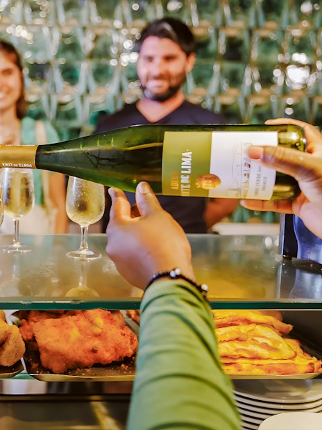 Tourists enjoying wine and snacks during Lisbon Food Walk in Baixa.