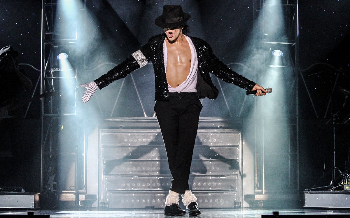 Performer in MJ Live show, Vegas, dancing on stage with iconic pose.