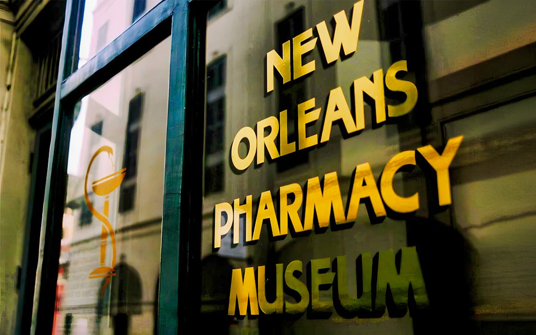 New Orleans Pharmacy Museum sign reflecting historic building.