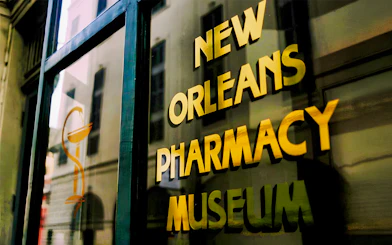 New Orleans Pharmacy Museum sign reflecting historic building.