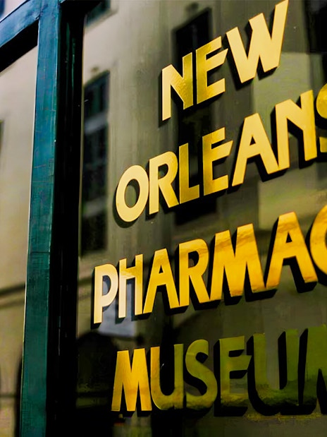 New Orleans Pharmacy Museum sign reflecting historic building.