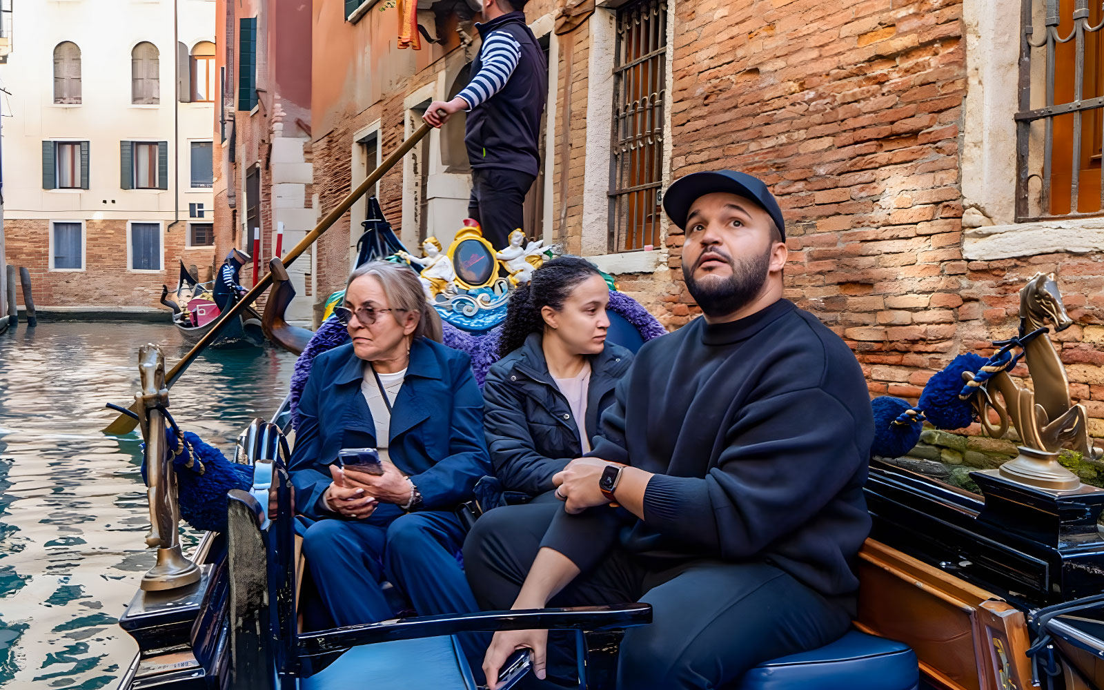 Gondola ride with people on a canal in Venice, Italy.