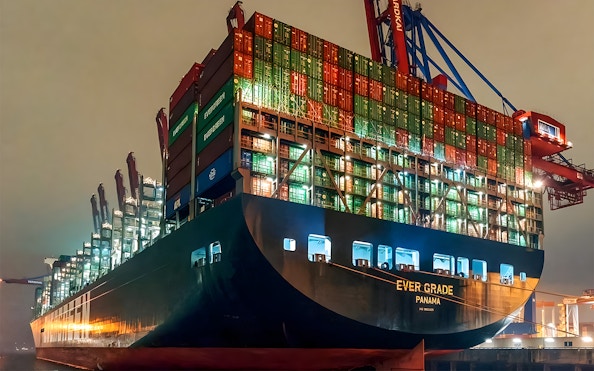 Cargo ship illuminated at night in Grand Harbor during evening lights cruise.