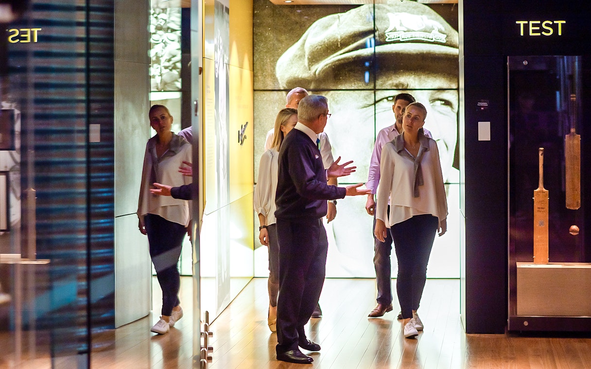 Guide explaining memorabilia at the Bradman Collection exhibit.