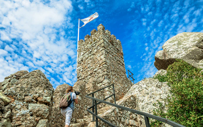 Visitor climbing steps at Moorish Castle, Sintra, Portugal.