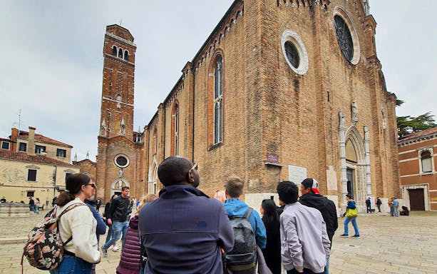 Tour group exploring Basilica dei Frari in Venice.