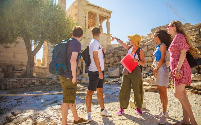 Tour group with guide at the Acropolis, Athens, exploring ancient ruins.