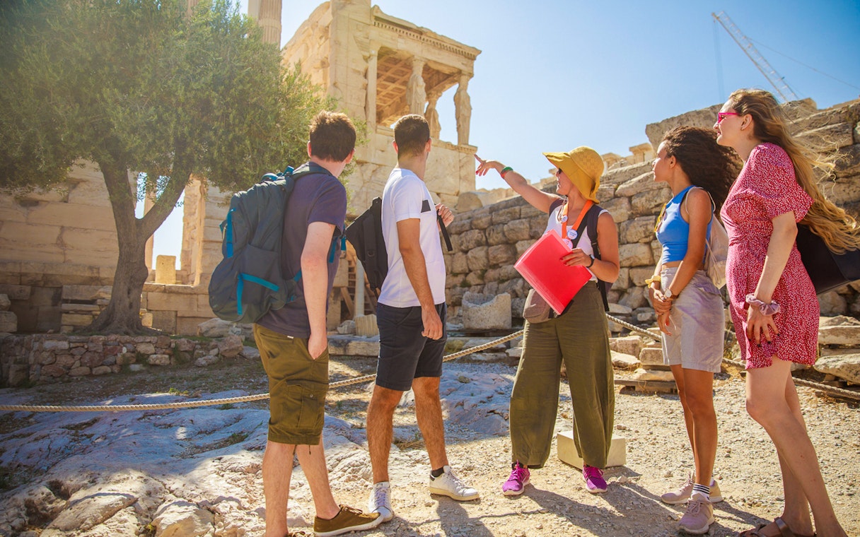 Tour group with guide at the Acropolis, Athens, exploring ancient ruins.