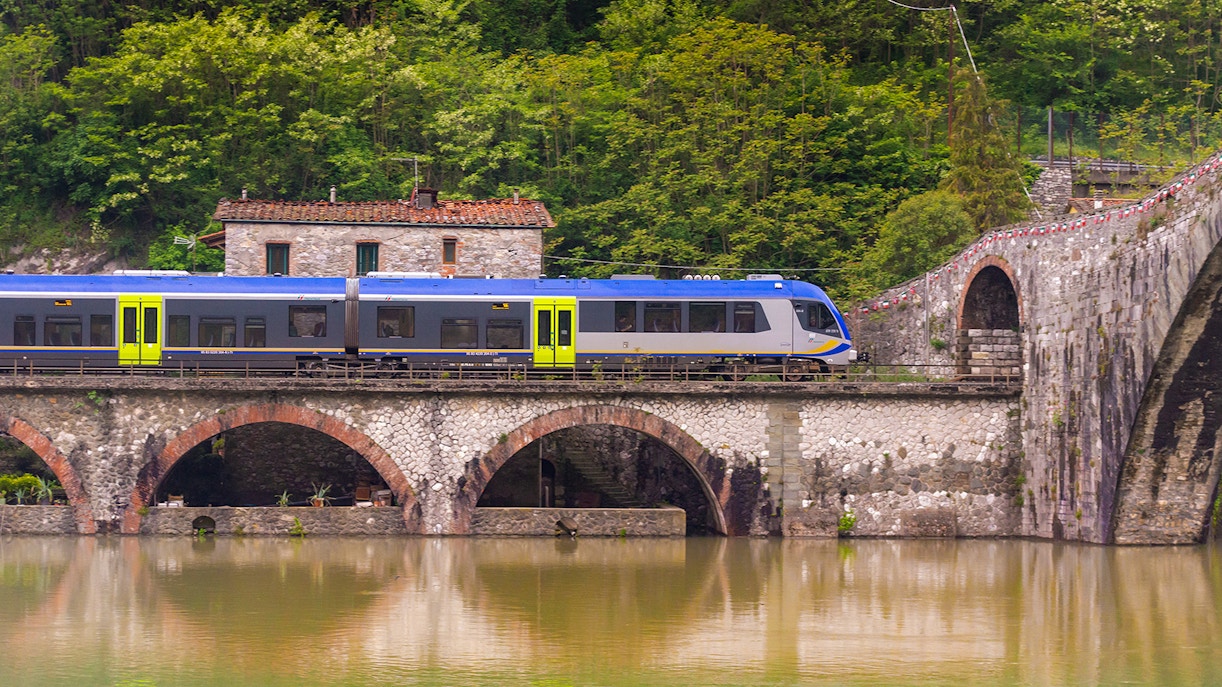 Treno che passa su un ponte antico a Pisa