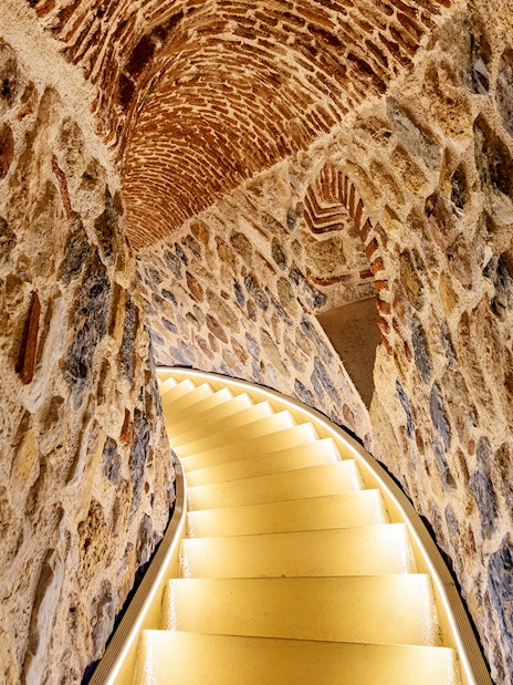 Staircase inside Galata Tower, Istanbul, with stone walls and arched ceiling.