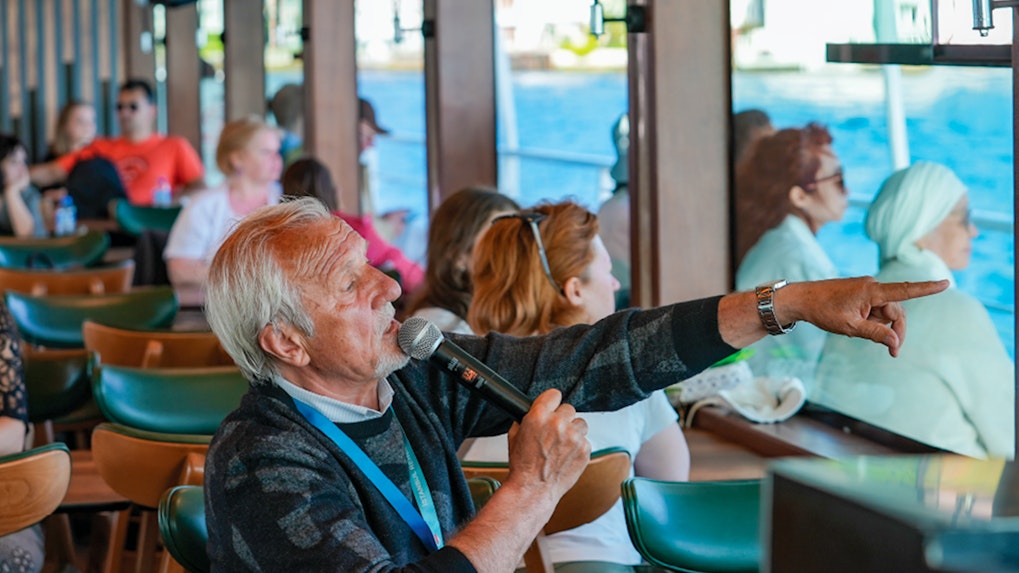 Live guide directing tourists on Bosphorus Afternoon Cruise.