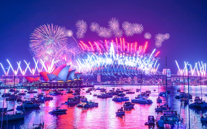 Sydney Harbour fireworks display with boats during light show cruise.