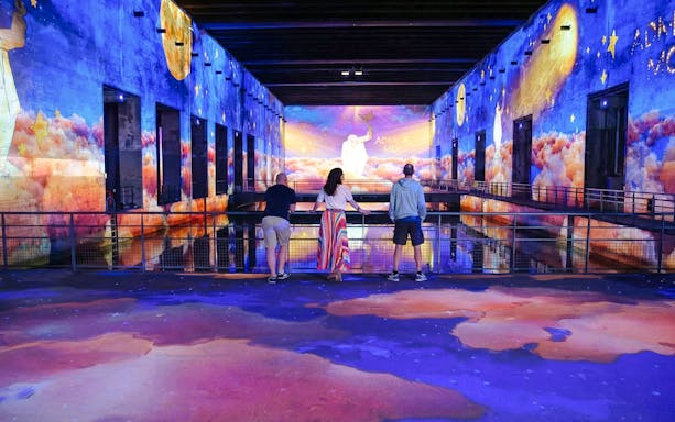 Visitors viewing "The Little Prince" immersive display at Bassins des Lumières, Bordeaux.