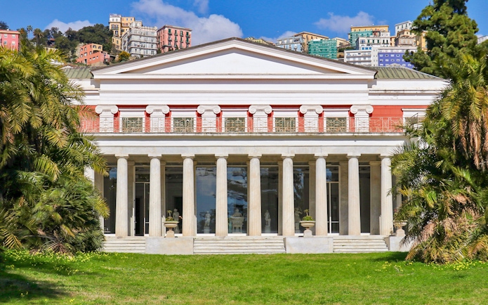 Villa Pignatelli facade with columns and surrounding greenery in Naples, Italy.