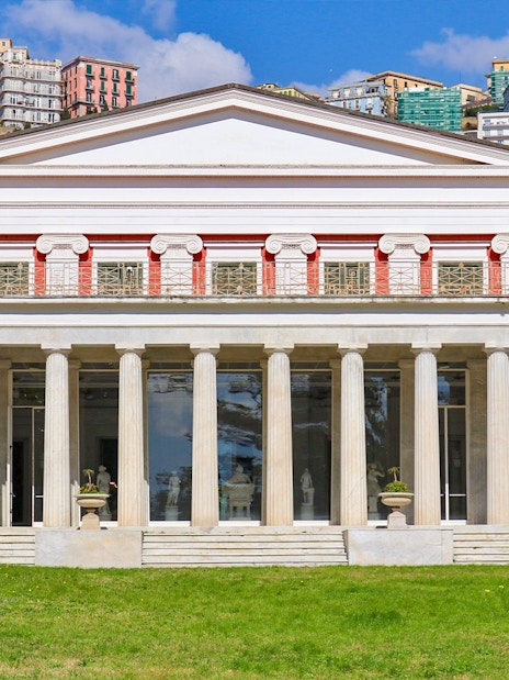 Villa Pignatelli facade with columns and surrounding greenery in Naples, Italy.