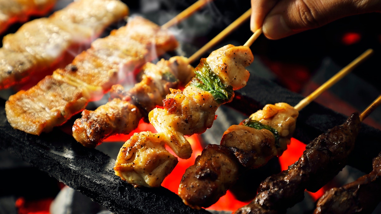 Yakitori skewers grilling over charcoal embers in Japan.