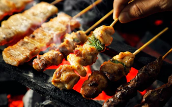 Yakitori skewers grilling over charcoal embers in Japan.