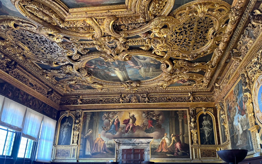 Doge's Palace interior with ornate gilded ceiling and Renaissance paintings, Venice.